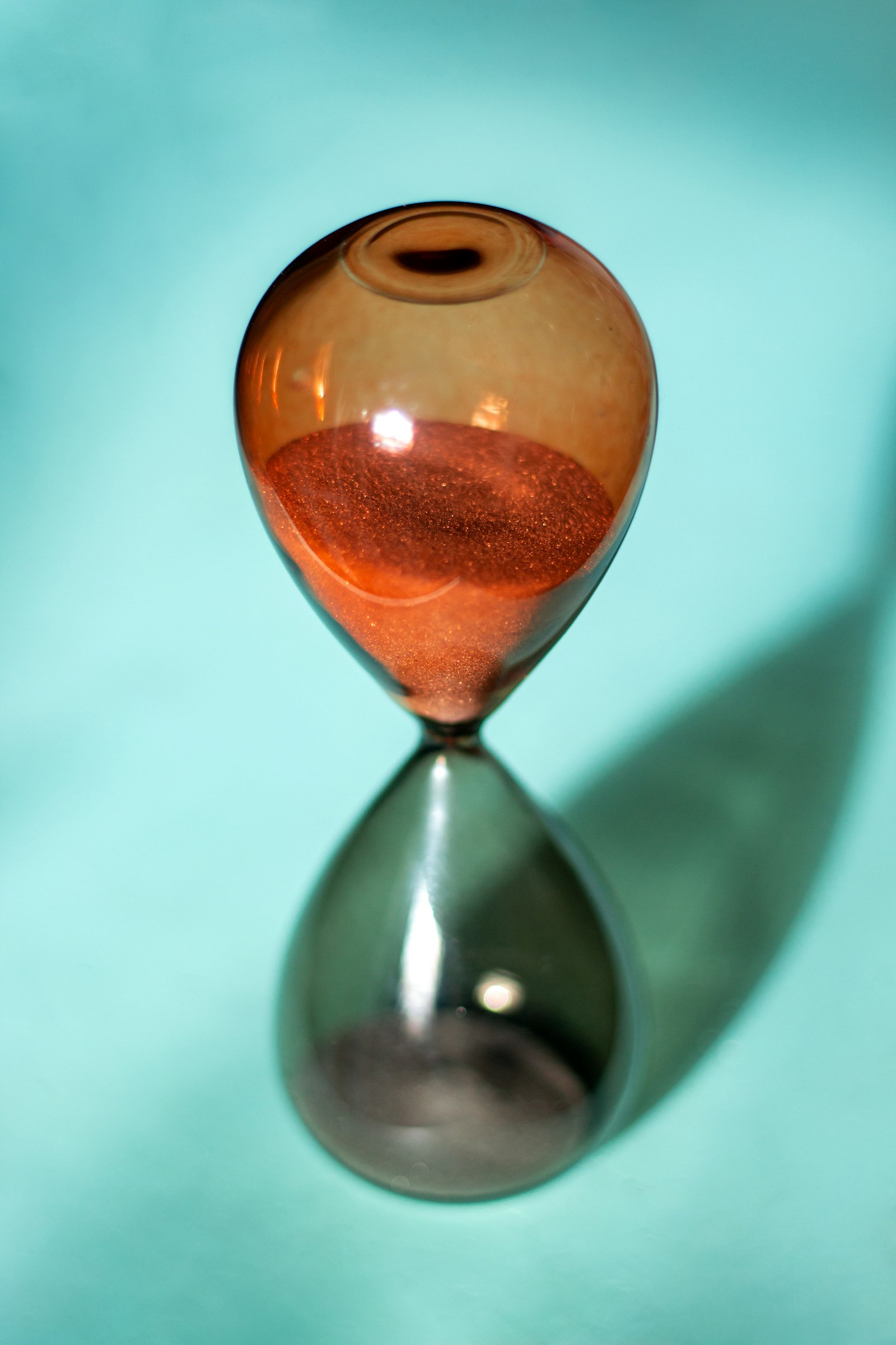 A clear glass hourglass on a white surface
