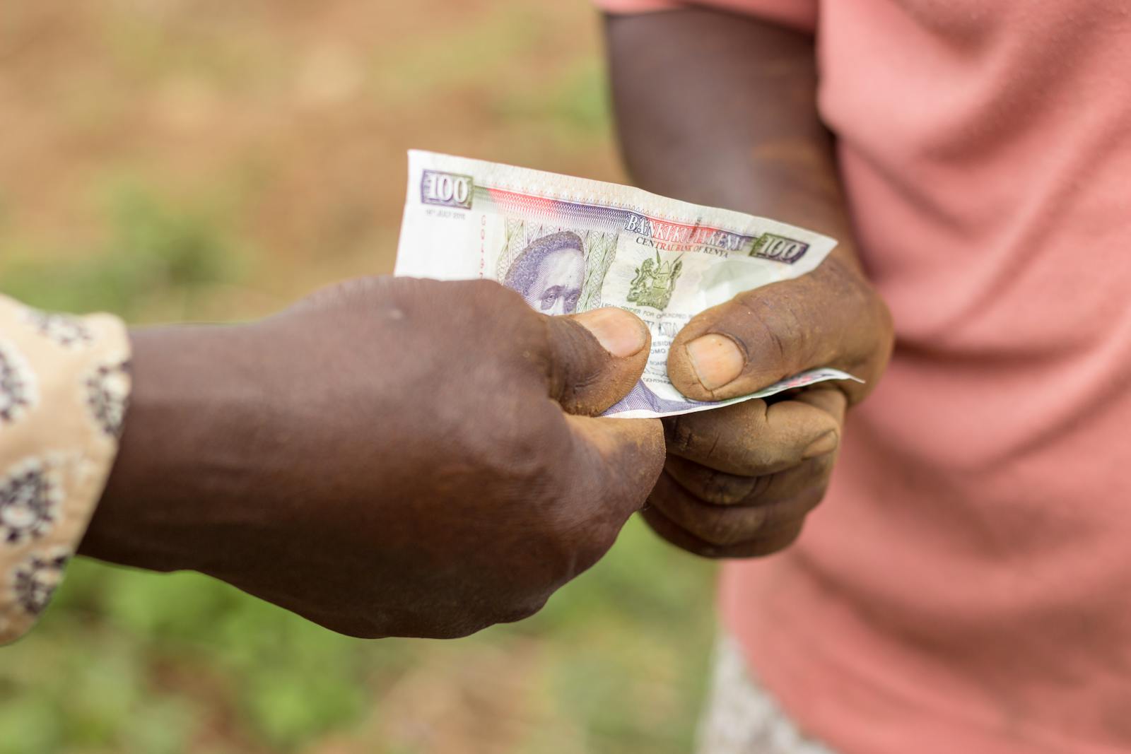 Two people exchanging cash by hand